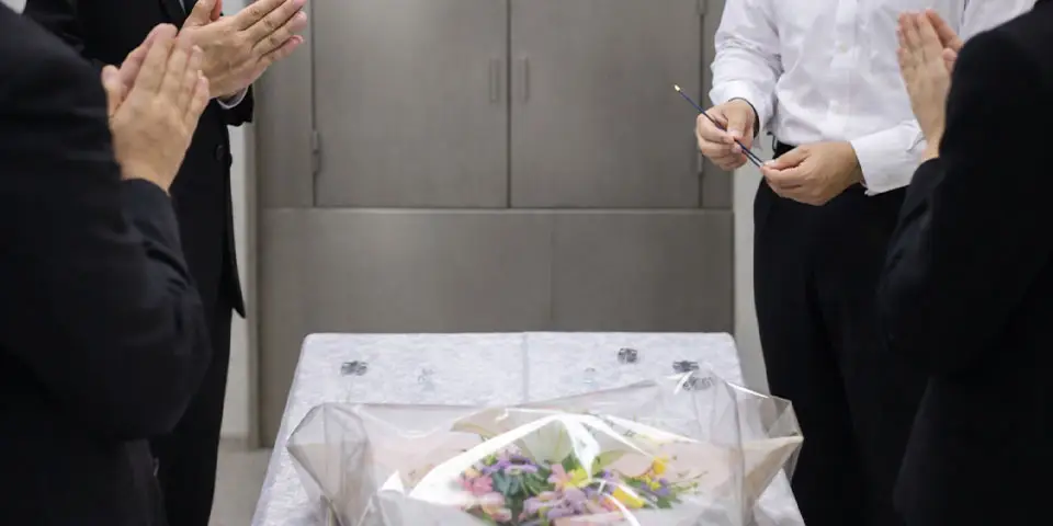 火葬炉の前で故人さまに花を手向け、最後のお別れを行なっている様子。